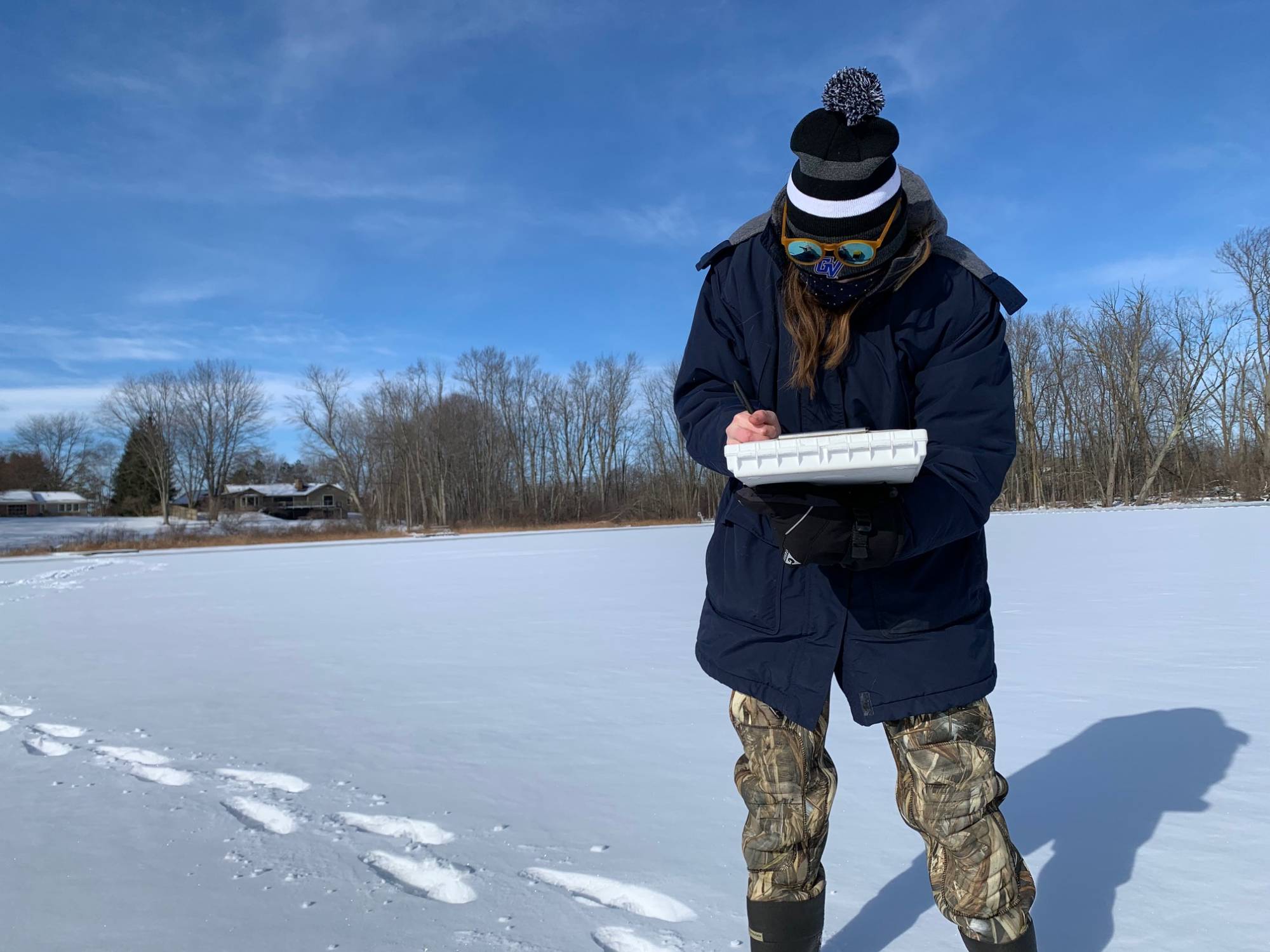 Graduate student Ellen Foley measuring water quality at Church Lake during winter weather.